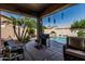 Relaxing outdoor patio with a built-in BBQ, seating, and a view of the beautiful pool area at 10413 E Emelita Ave, Mesa, AZ 85208