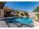 Sparkling swimming pool, covered patio, and palm trees enhance this private backyard oasis at 10413 E Emelita Ave, Mesa, AZ 85208