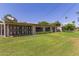 Backyard view of a home with lush grass, mature landscaping, and secure decorative iron fencing at 10621 W Oakmont Dr, Sun City, AZ 85351