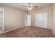 Bedroom featuring carpet, a ceiling fan, and an ensuite bathroom and closet at 10621 W Oakmont Dr, Sun City, AZ 85351