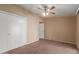 Neutral bedroom with a ceiling fan, carpet flooring, and a closet with white doors at 10621 W Oakmont Dr, Sun City, AZ 85351