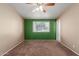 Bedroom with neutral walls, carpet flooring, a ceiling fan, and a large window overlooking the front yard at 10621 W Oakmont Dr, Sun City, AZ 85351