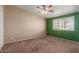 Bedroom featuring neutral walls, carpet flooring, a ceiling fan, and a window overlooking the yard at 10621 W Oakmont Dr, Sun City, AZ 85351
