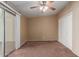 Bedroom features carpet, ceiling fan, sliding glass door, and a double-door closet at 10621 W Oakmont Dr, Sun City, AZ 85351
