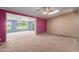 Open living room features a brick wall, ceiling fan, neutral carpet, and golf course views at 10621 W Oakmont Dr, Sun City, AZ 85351