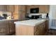 Traditional-style kitchen with wood cabinets, center island, and black appliances at 11596 W Sierra Dawn Blvd # 247, Surprise, AZ 85378