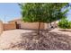 Landscaped backyard featuring rock ground cover and a mature shade tree creating a peaceful outdoor space at 11691 W Cactus Wren Ct, Surprise, AZ 85378