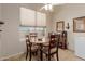 Cozy dining area featuring a wooden table, four chairs, and a ceiling fan at 11691 W Cactus Wren Ct, Surprise, AZ 85378