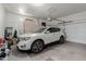 Spacious garage with a white SUV parked inside; additional storage cabinets are visible at 11691 W Cactus Wren Ct, Surprise, AZ 85378
