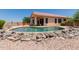 Lush backyard with a shimmering pool, rock landscaping, and comfortable outdoor seating at 11691 W Cactus Wren Ct, Surprise, AZ 85378