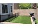 A fenced backyard with artificial turf and brick perimeter offers a private outdoor space for relaxation and recreation at 1465 S Longspur S Ln, Gilbert, AZ 85296