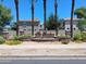 Well-maintained community entrance featuring mature palm trees and colorful landscaping welcoming you to The Gardens at 1465 S Longspur S Ln, Gilbert, AZ 85296