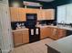 Functional kitchen with light wood cabinets, black appliances, and ample counter space for meal preparation at 1465 S Longspur S Ln, Gilbert, AZ 85296