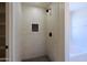 Modern shower features light colored tile, a built in shelf, black hardware, and tile flooring at 16447 W Cottonwood St, Surprise, AZ 85388