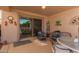 Covered patio with comfortable seating adjacent to sliding glass door at 16554 W Saguaro Ln, Surprise, AZ 85388