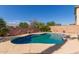 A beautiful in-ground pool with a uniquely shaped concrete deck and wall decorations at 16554 W Saguaro Ln, Surprise, AZ 85388
