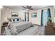 This bright bedroom features neutral decor, updated ceiling fan and modern curtains for a fresh, cozy feel at 16842 N 103Rd Dr, Sun City, AZ 85351