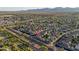 Expansive aerial view of a neighborhood with mountain views in the distance and lush desert vegetation at the street line at 17416 W Ventura St, Surprise, AZ 85388