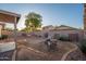 Backyard featuring a covered patio, fire pit, seating area, desert landscaping, and a view of the neighbors at 17416 W Ventura St, Surprise, AZ 85388