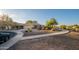 Charming single-story home with well-maintained desert landscaping, mature trees, and a paved walkway at 17416 W Ventura St, Surprise, AZ 85388