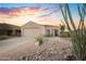 Charming single-story home with a well-manicured xeriscaped front yard and a beautiful sunset sky at 17416 W Ventura St, Surprise, AZ 85388