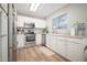 A bright kitchen with white cabinets, stainless steel appliances, and a tile backsplash at 17416 W Ventura St, Surprise, AZ 85388