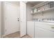 This laundry room features a washer and dryer, storage shelves, and a door to the outside at 17416 W Ventura St, Surprise, AZ 85388