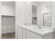 Bright bathroom featuring a double vanity with white cabinets, large mirror and a separate shower at 17830 W Mission Ln, Waddell, AZ 85355