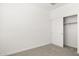 Simple, carpeted bedroom with a closet at 17830 W Mission Ln, Waddell, AZ 85355