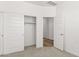 Bright, carpeted bedroom with closet and view to an adjacent room at 17830 W Mission Ln, Waddell, AZ 85355