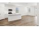 Open-concept kitchen with white cabinets, island, stainless appliances, flowing into a bright living space at 17830 W Mission Ln, Waddell, AZ 85355