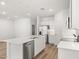 Bright, open kitchen with stainless steel appliances, white cabinetry, and a large central island at 17830 W Mission Ln, Waddell, AZ 85355