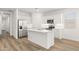 Bright kitchen with stainless steel fridge and white island at 17830 W Mission Ln, Waddell, AZ 85355