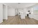 Bright, open living space with luxury vinyl flooring and white paint, seamlessly connecting to the modern kitchen at 17830 W Mission Ln, Waddell, AZ 85355