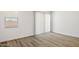 Well-lit, airy room with wood-style flooring and white walls, featuring a large window with blinds at 17830 W Mission Ln, Waddell, AZ 85355