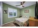 Comfortable bedroom has a floral bedspread, ceiling fan and plenty of natural light at 20194 N Riverbank Rd, Maricopa, AZ 85138