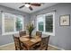 A cozy dining area with a wooden table, seating for four, and natural light from shuttered windows at 20194 N Riverbank Rd, Maricopa, AZ 85138