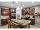 A modern kitchen with wood cabinets, stainless steel appliances and a granite countertop island with seating at 20194 N Riverbank Rd, Maricopa, AZ 85138