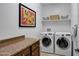 Well-organized laundry room featuring modern washer and dryer units, cabinets, and countertop space at 20194 N Riverbank Rd, Maricopa, AZ 85138