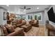 Spacious living area featuring neutral walls, tile flooring and comfortable leather furniture with a ceiling fan at 20194 N Riverbank Rd, Maricopa, AZ 85138