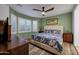 Cozy main bedroom features a decorative bedspread, ceiling fan and shuttered windows at 20194 N Riverbank Rd, Maricopa, AZ 85138