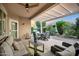 Covered patio with outdoor dining, seating, grill, lush landscaping, and exterior lighting at 20194 N Riverbank Rd, Maricopa, AZ 85138