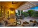 Warmly lit patio with outdoor seating, dining, grill, and views of the lush backyard at 20194 N Riverbank Rd, Maricopa, AZ 85138