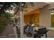 Covered patio with comfortable seating, dining area, grill, and landscaped backyard at 20194 N Riverbank Rd, Maricopa, AZ 85138