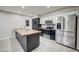 Modern kitchen with stainless steel appliances, black and white cabinets and large center island at 2122 E Radcliffe Dr, Tempe, AZ 85283