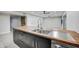 Close up of the modern kitchen island featuring wood countertops, sink, and sleek black cabinetry at 2122 E Radcliffe Dr, Tempe, AZ 85283