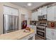 Contemporary kitchen with white cabinetry, stainless steel appliances, and a breakfast bar at 21893 N 261St N Ave, Buckeye, AZ 85396