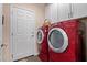 Laundry room with red appliances and white storage cabinets at 21893 N 261St N Ave, Buckeye, AZ 85396