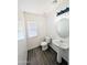 Clean half bathroom featuring wood-look floors, pedestal sink, and toilet at 22523 W Pima St, Buckeye, AZ 85326