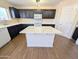 Modern kitchen featuring dark cabinets, an island with countertop and wood flooring at 22523 W Pima St, Buckeye, AZ 85326